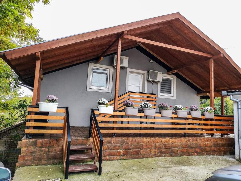 a house with a porch with potted plants on it at S. A. L. Prenociste in Zrenjanin