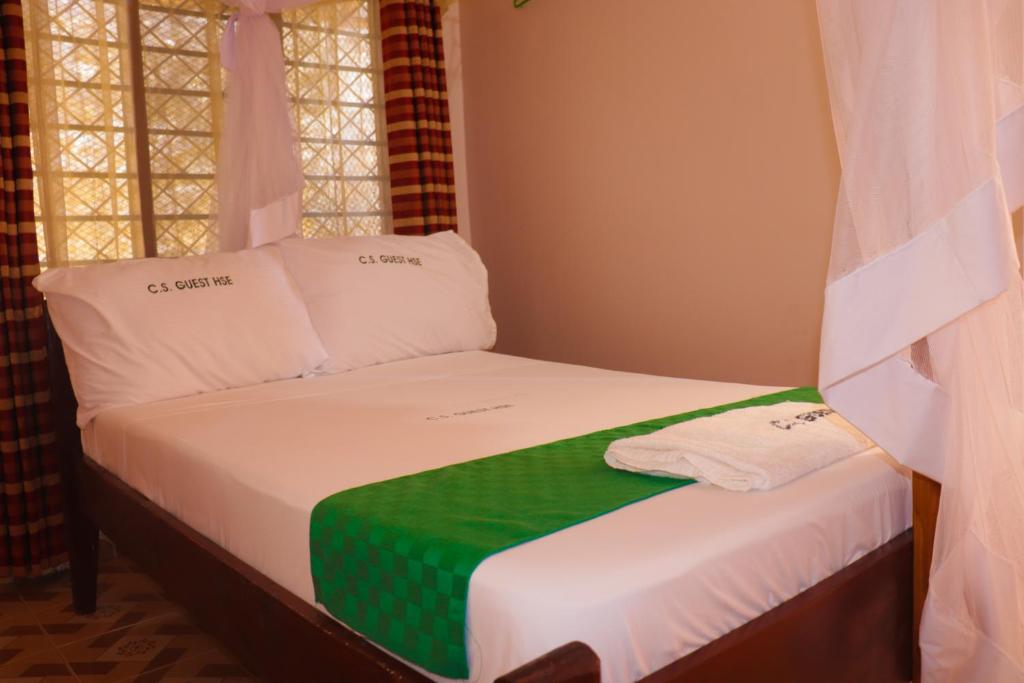 - un petit lit avec une couverture verte et blanche dans l'établissement Cs Apartment Mombasa Mtwapa, à Mombasa