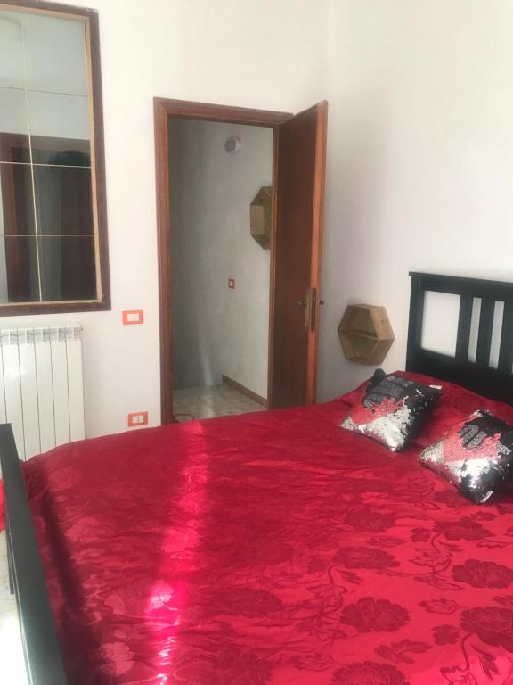 1 dormitorio con cama roja y manta roja en Pernoicasavacanze, en Caprarola