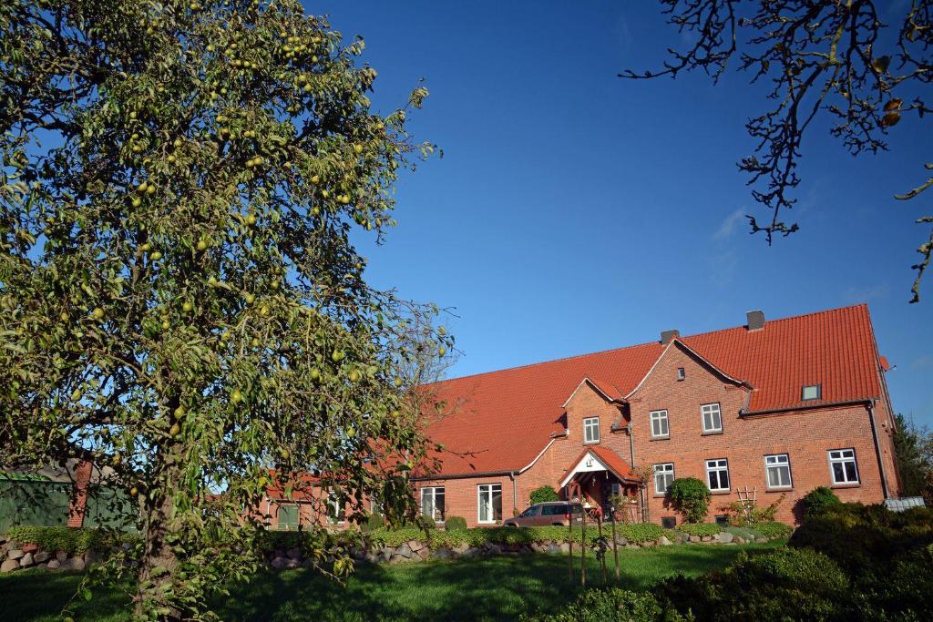 a large brick house with a red roof at Hof Brinker - Bauernstube in Boiensdorf