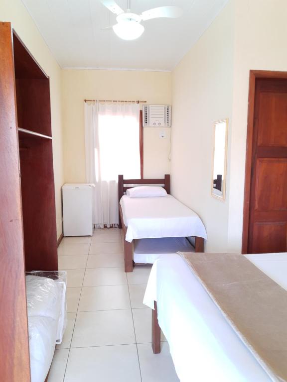 een kamer met 2 bedden en een raam bij Pousada Brisa do Leste in Paraty