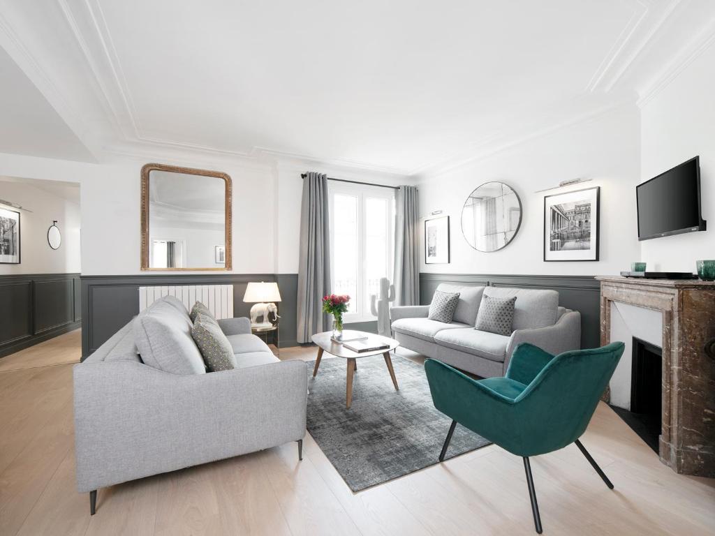 un salon avec un canapé et une chaise dans l'établissement LivinParis - Luxury 3 Bedrooms Opera II, à Paris