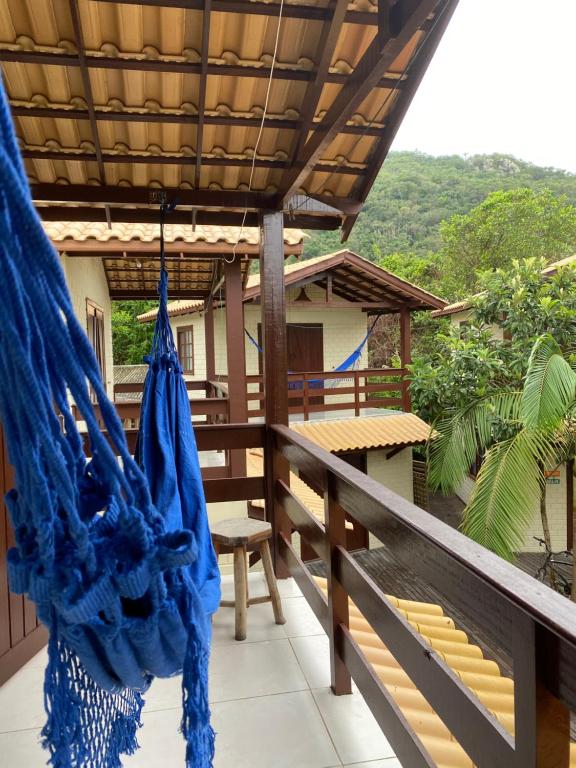 a blue hammock hanging on a balcony of a house at Pousada Familia Quandt in Guarda do Embaú