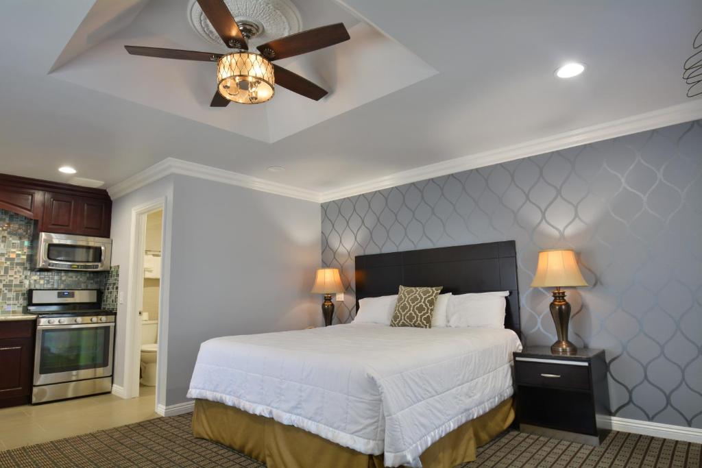 a bedroom with a bed and a ceiling fan at Crystal Lodge Motel in Ventura