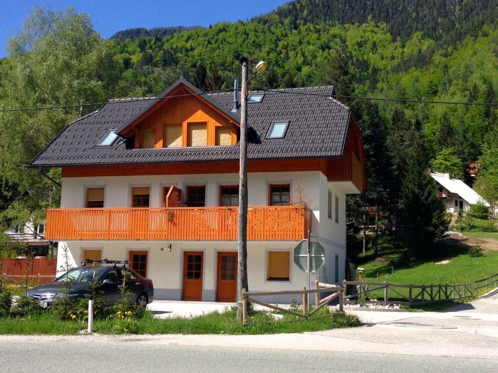 ein großes Haus mit einem davor geparkt in der Unterkunft Apartment Brina in Kranjska Gora