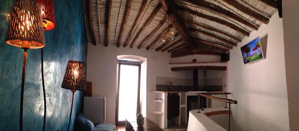 un soggiorno con 2 lampade e un soffitto di Casas de la Judería, judería nueva a Cáceres