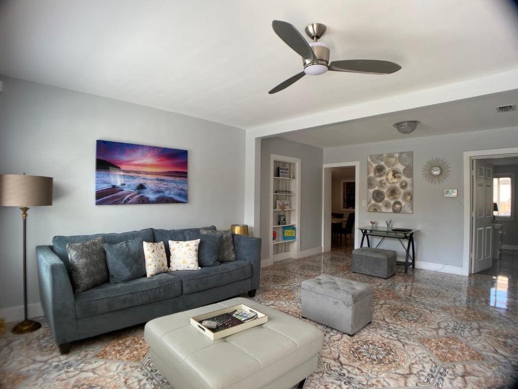 - un salon avec un canapé bleu et un ventilateur de plafond dans l'établissement Main House 3 Bed 2 Bath & Guest House 1 Bed 1 Bath, à Miami