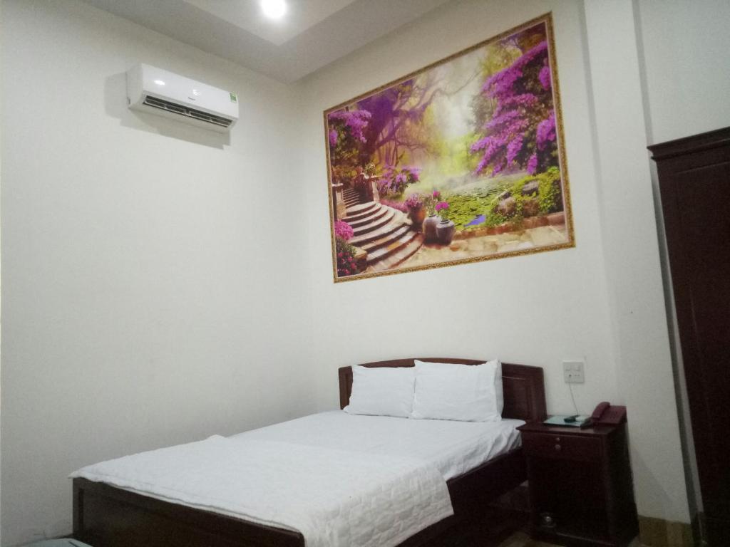 ein Schlafzimmer mit einem Bett und einem Wandgemälde in der Unterkunft Manh Phat Guesthouse - Nhà Nghỉ Mạnh Phát in Cần Thơ