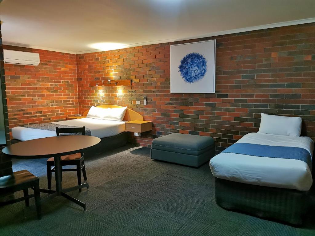 A bed or beds in a room at Town House Motor Inn