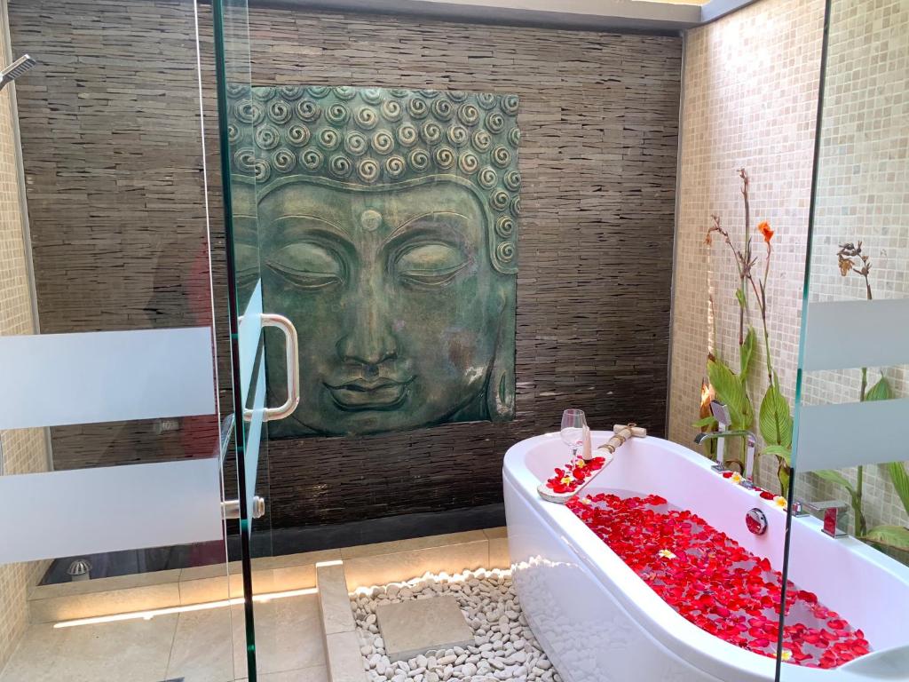 a bathroom with a large green face on the wall at Beachfront Rice Field View Lovina Villa Serenity Bali in Pengastulan