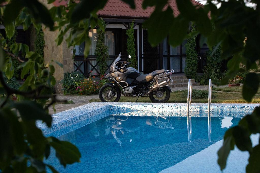 a motorcycle parked next to a swimming pool at Guest House Orlinoe - Sevastopol in Orlinoye