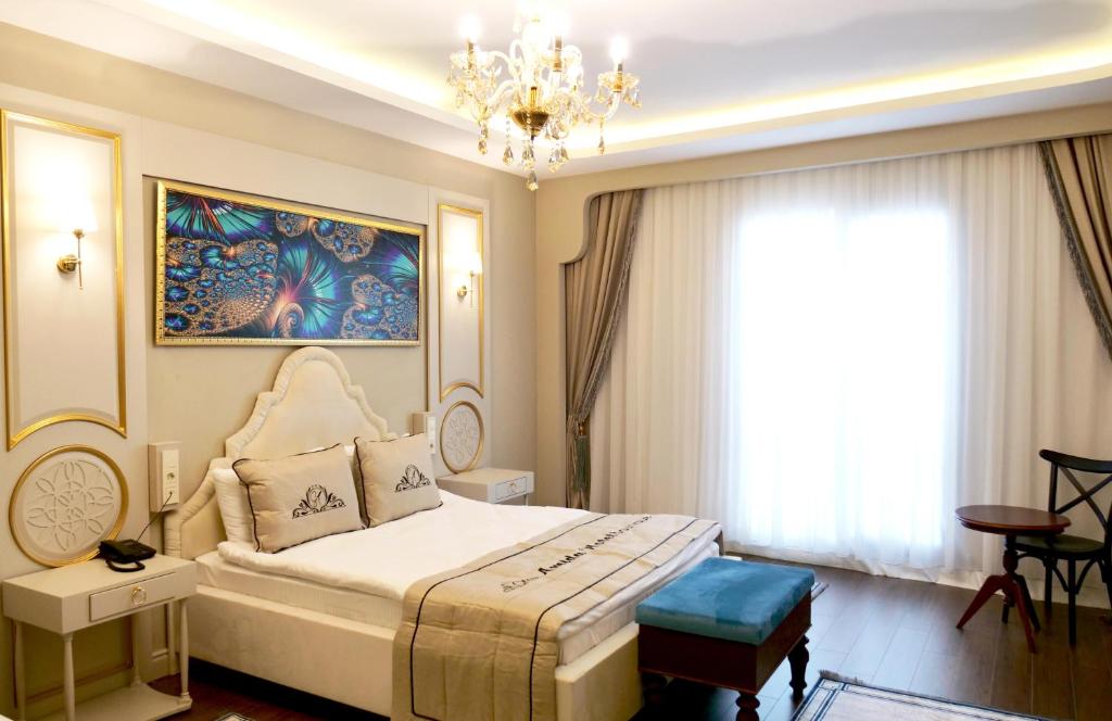 a bedroom with a large bed and a chandelier at Amida Boutique Otel in Diyarbakır