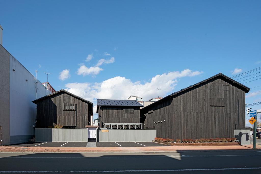 three wooden buildings on the side of a street at Condominium ISHITEI Furano in Furano