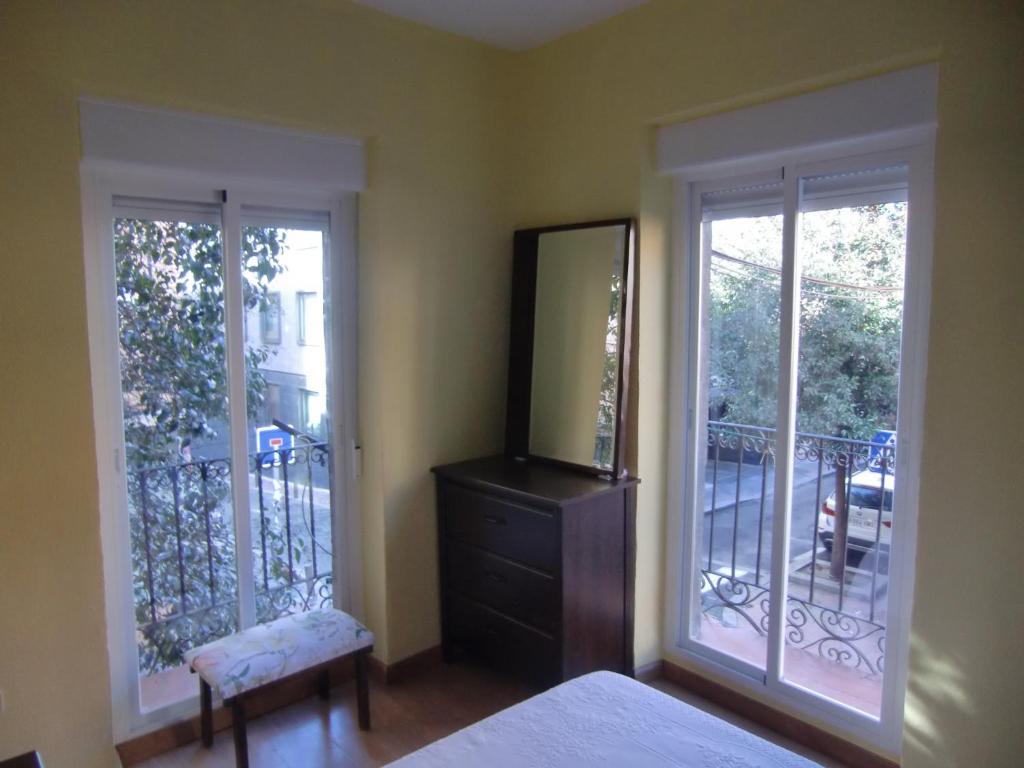 1 dormitorio con 2 ventanas y vestidor con espejo en M17 Madrid Centro apartamento con wifi, en Madrid