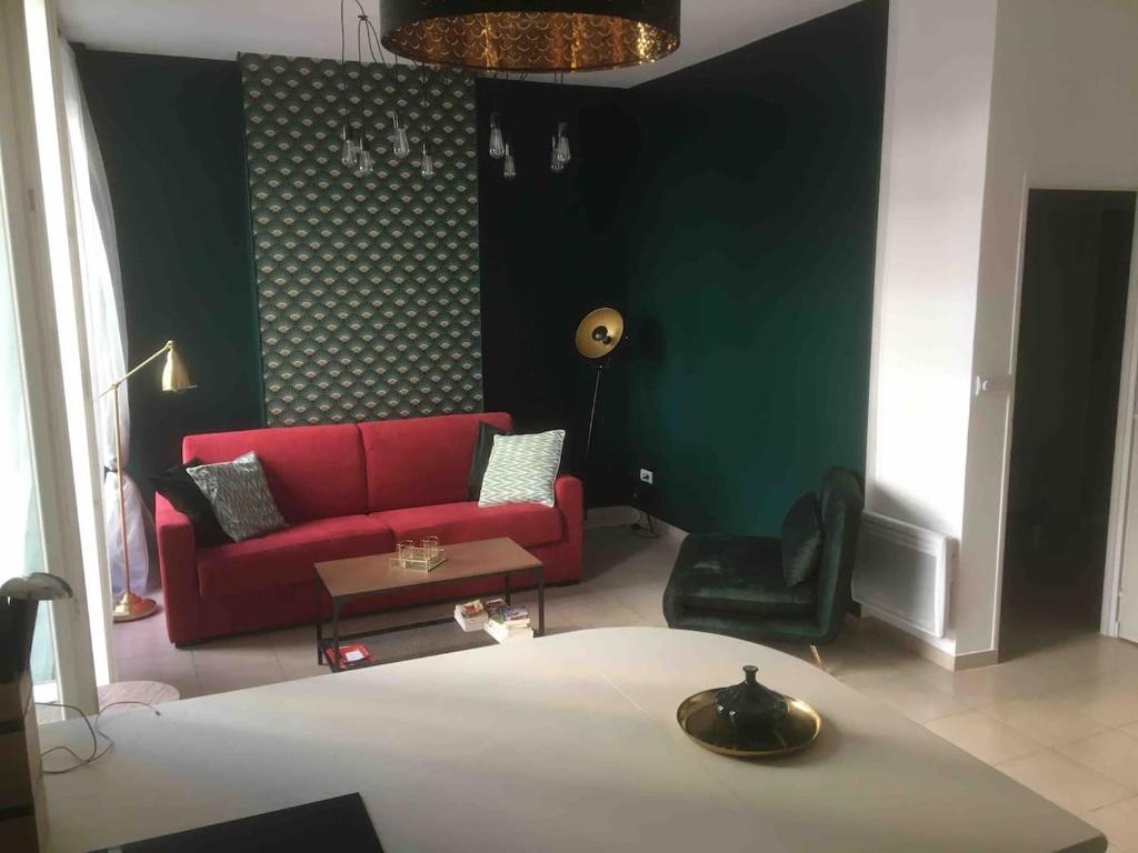 een woonkamer met een rode bank en een groene muur bij Terrasses du Port 5 mn, T2 moderne tout équipé 5 couchages in Marseille