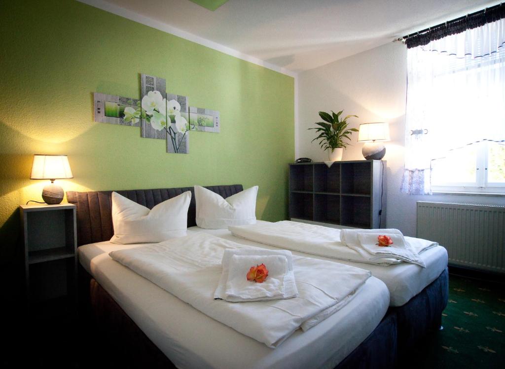 um quarto com duas camas com lençóis brancos e flores em Ratskeller Thum em Thum