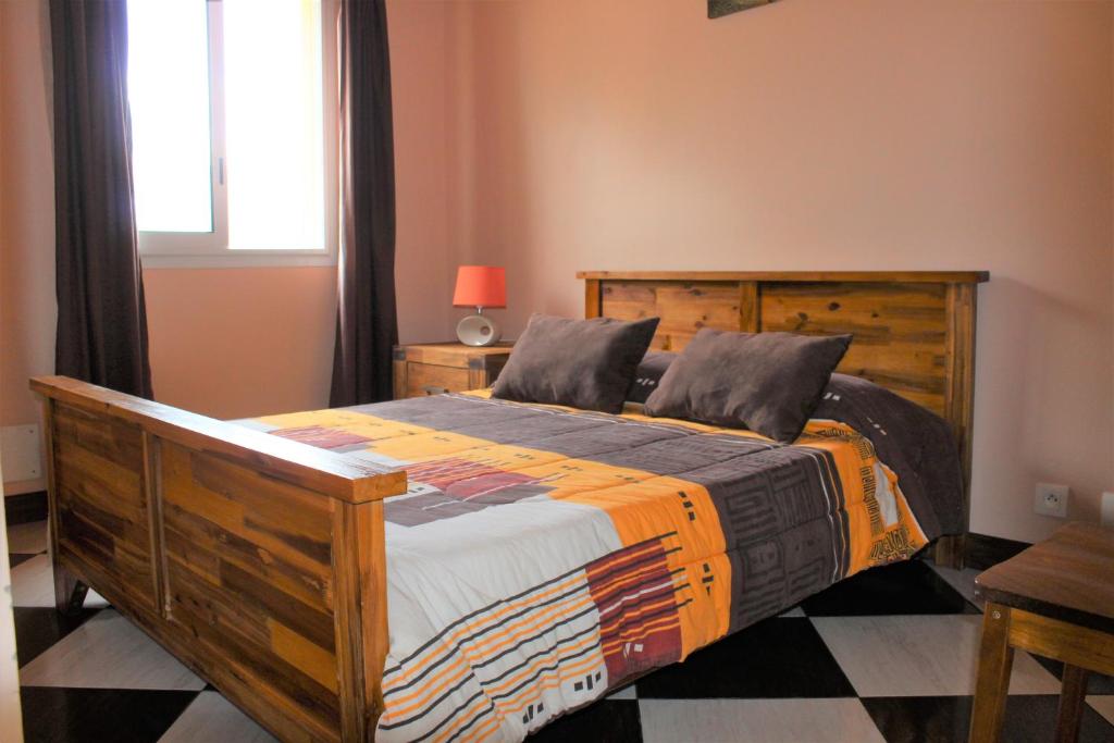 a bedroom with a wooden bed and a window at CASAMELIAS "casappart 2" in Cilaos