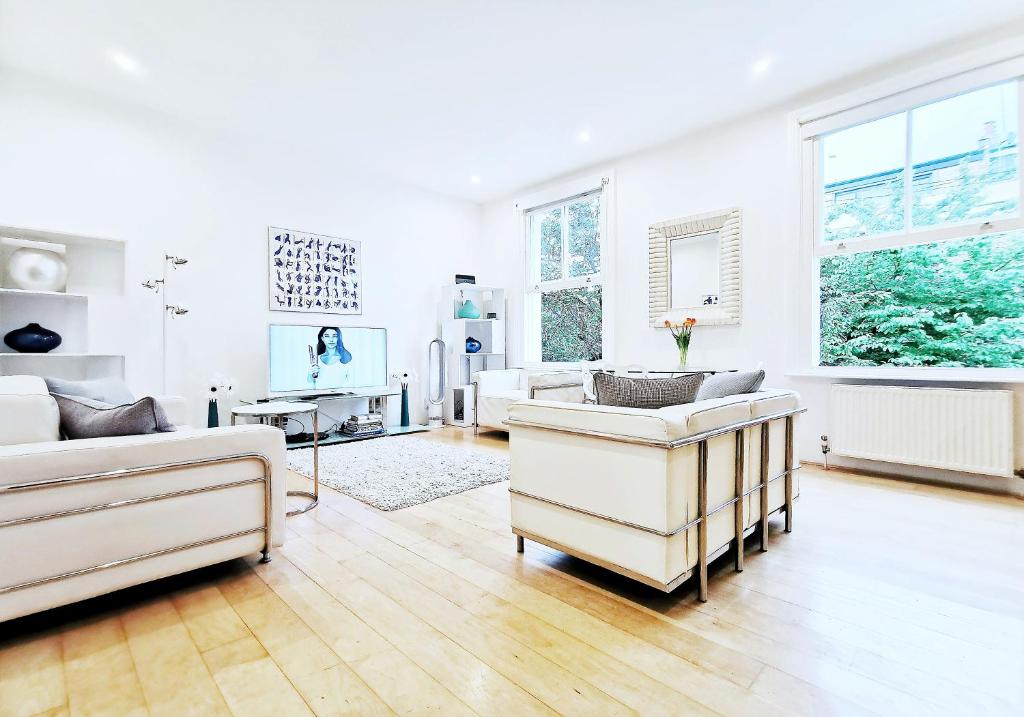 ロンドンにあるEden Luxury Apartmentsの白いリビングルーム(椅子2脚、ソファ付)