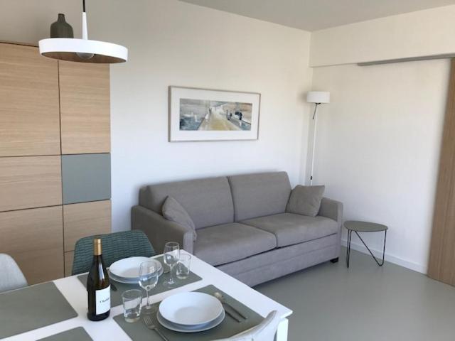 een woonkamer met een bank en een tafel bij Penthouse Sun Corner Knokke in Knokke-Heist