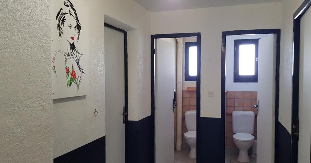 a bathroom with two toilets and two doors with a painting at Õ 2040 Chambre Mélèze in Saint-Véran