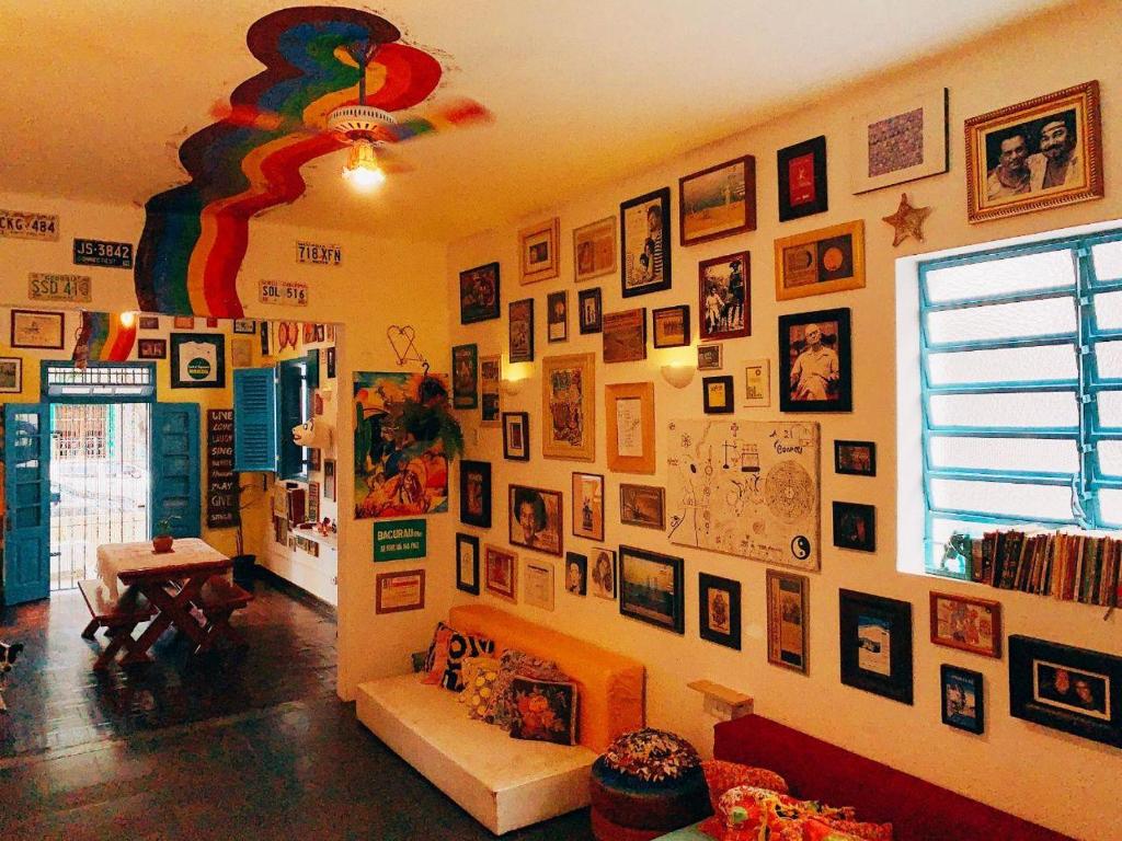 a living room with a wall full of pictures at Zili Pernambuco - Hostel Pousada in Recife