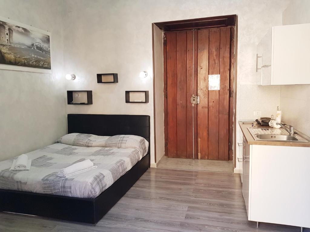 a bedroom with a bed and a kitchen with a sink at Napoli Central Loft in Naples
