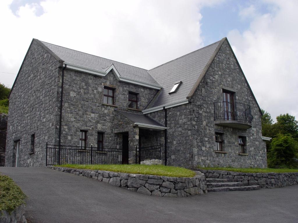 un gran edificio de piedra con techo gris en Clare's Rock Self-catering Accommodation, en Carron