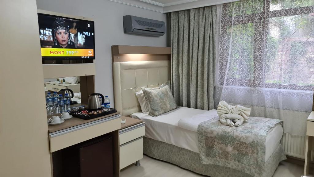 イスタンブールにあるOceans 7 Hotelのベッドとテレビが備わるホテルルームです。