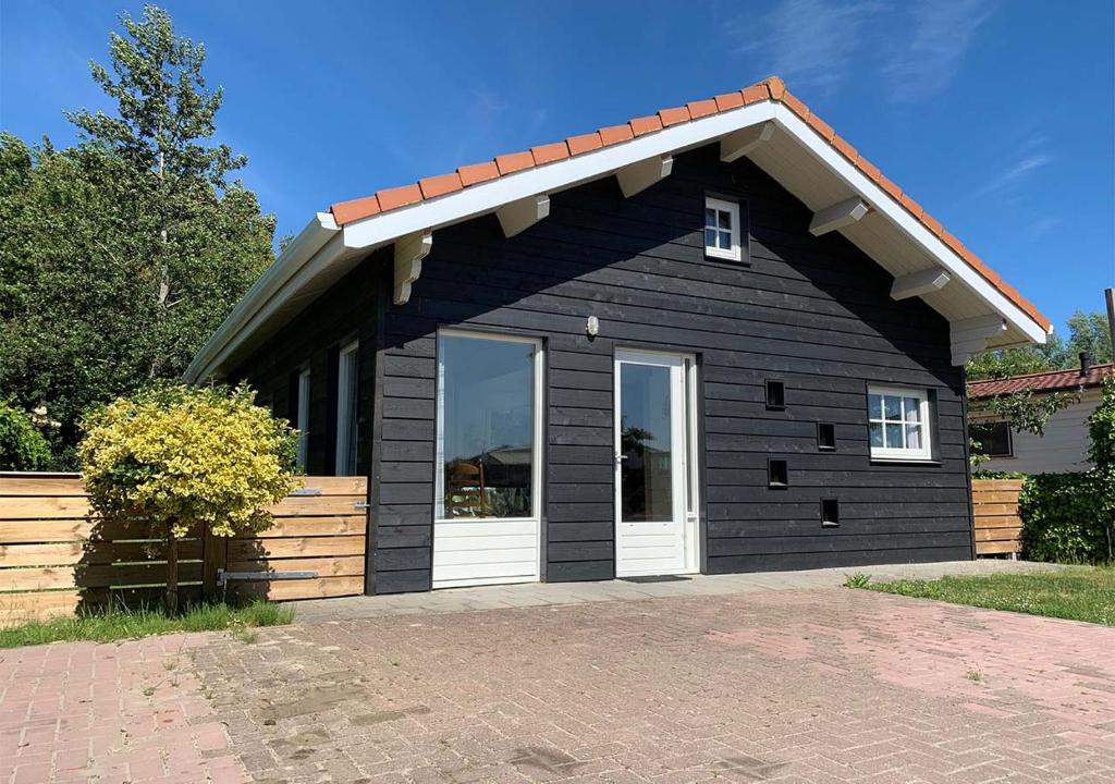 a black house with a white door at Chaletparc Krabbenkreek - Chalet 266 in Sint Annaland