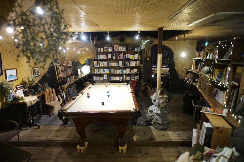 uma loja com uma mesa de bilhar no meio de uma sala em Worldtreck Dinner & Guesthouse Pise em Nagano