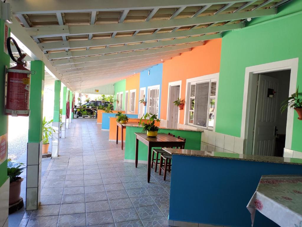 un pasillo de un restaurante con paredes y mesas coloridas en Pousada Flores de Bombinhas, en Bombinhas