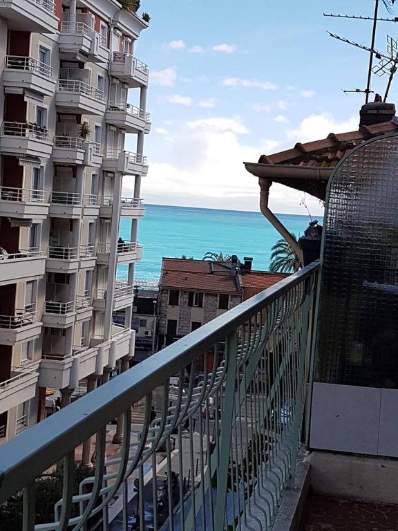 Elle comprend un balcon offrant une vue sur un bâtiment et l'océan. dans l'établissement Sci MDM, à Nice