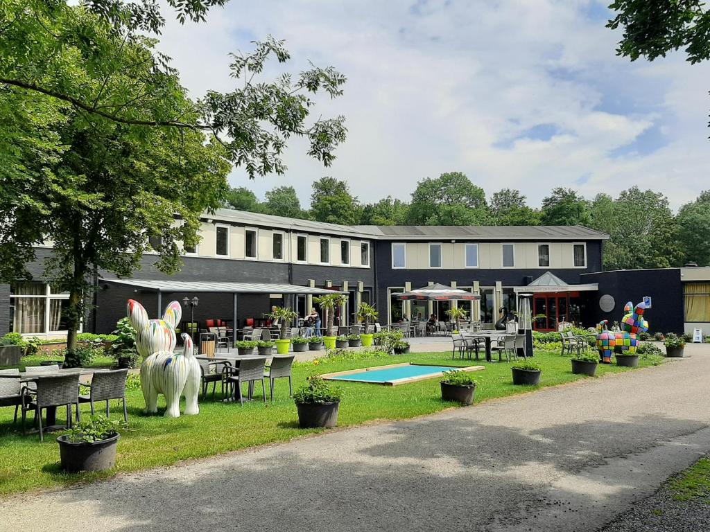 ein Gebäude mit Tischen und Stühlen davor in der Unterkunft Hotel De Elderschans in Aardenburg