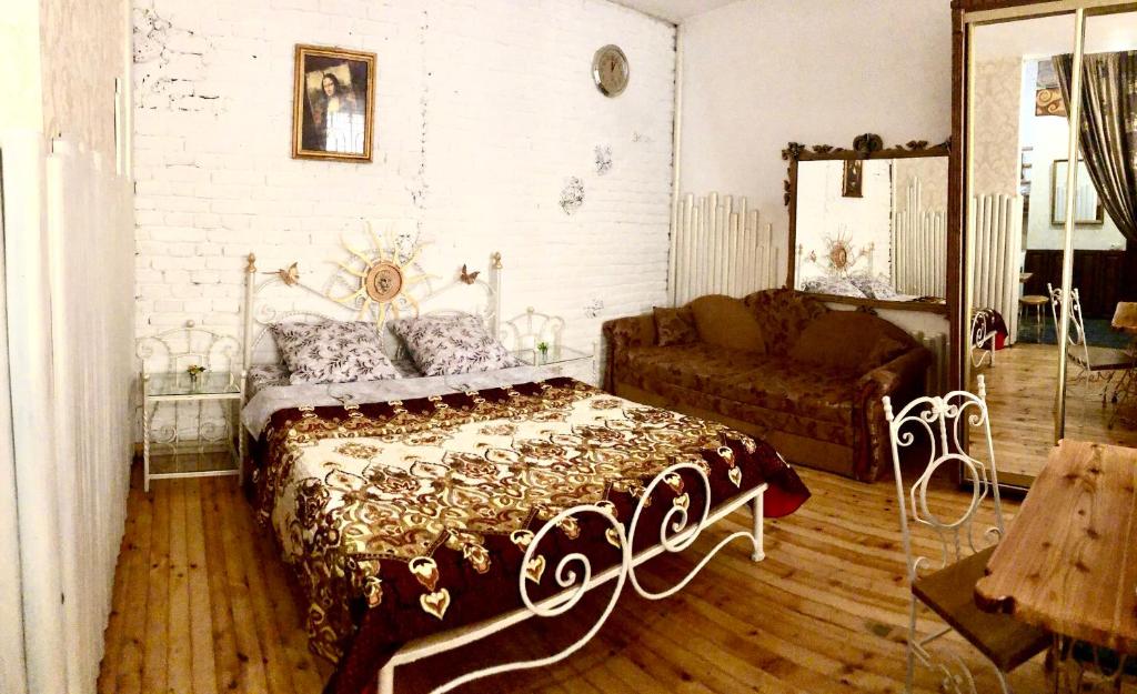 a bedroom with a bed and a couch at Exclusive Apartment on Square Rynok in Lviv