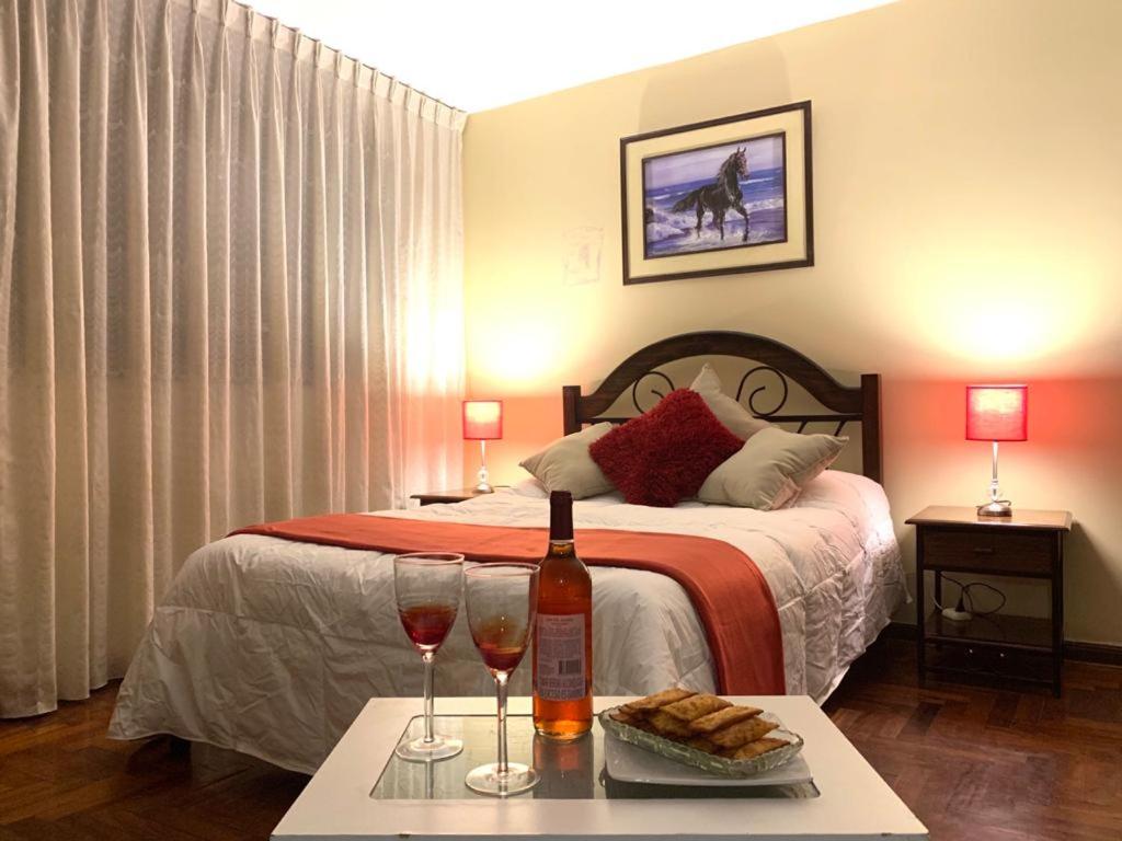 ein Schlafzimmer mit einem Bett mit zwei Gläsern Wein in der Unterkunft Hotel Colibri in San Vicente de Cañete