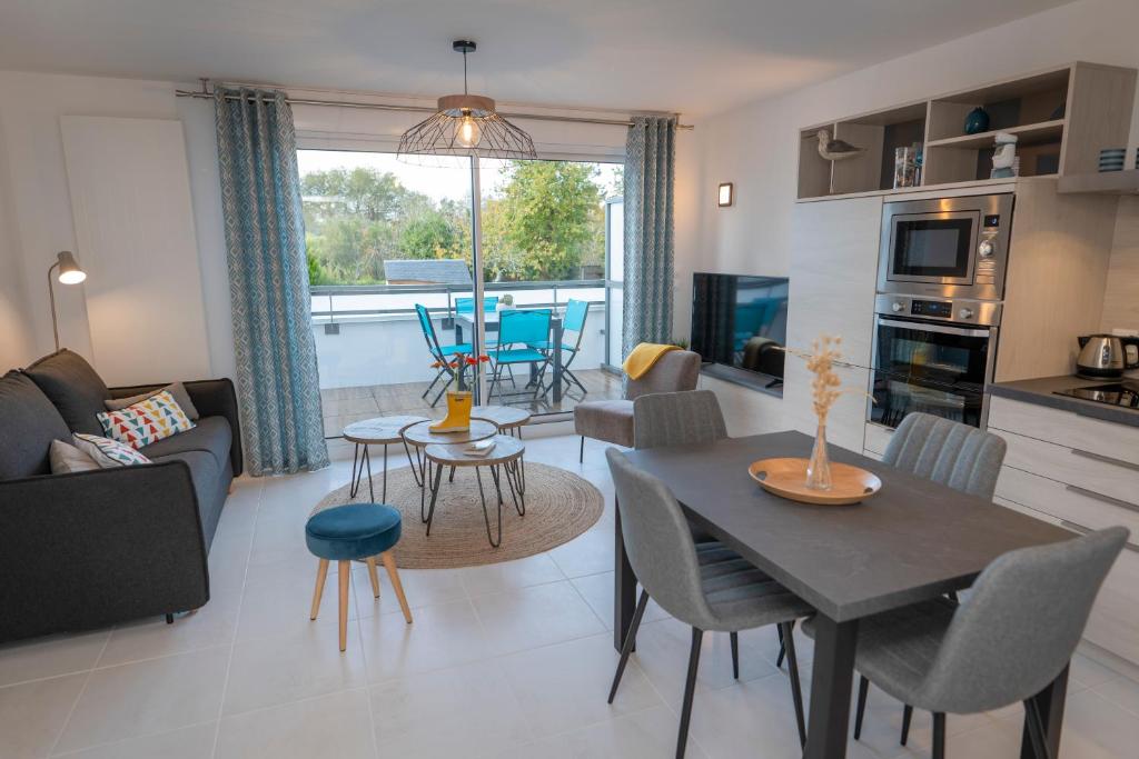 een keuken en een woonkamer met een tafel en stoelen bij Le Golfe du Morbihan et ses sentiers côtiers in Vannes