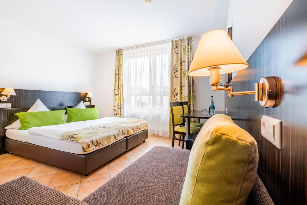 1 dormitorio con cama, sofá y mesa en My Airport Hotel STUTTGART-AIRPORT-MESSE en Leinfelden-Echterdingen