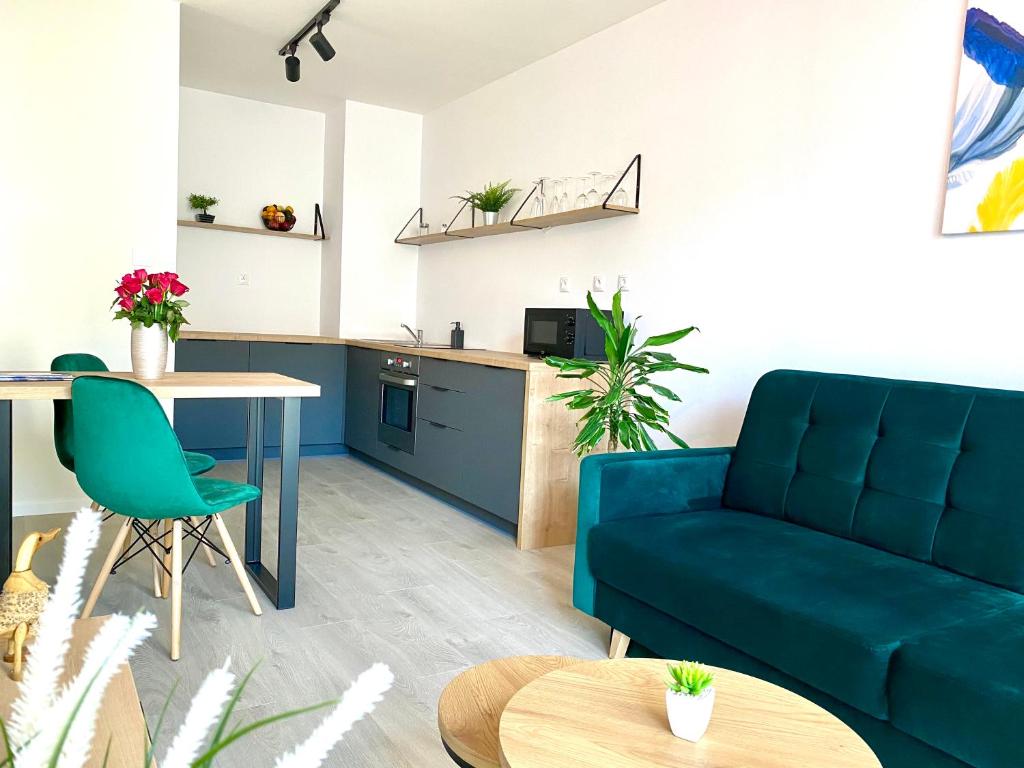 a living room with a blue couch and a table at Apartment Malá Praha in Žilina