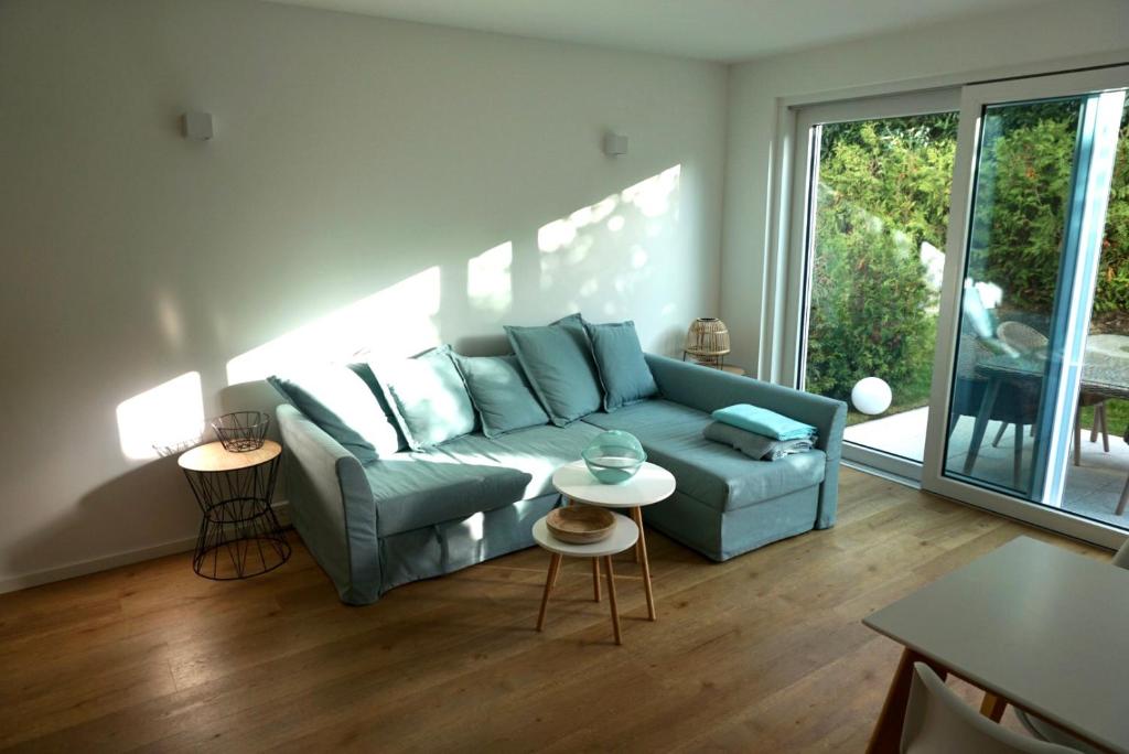 ein Wohnzimmer mit einem blauen Sofa und einem Tisch in der Unterkunft Strandglück in Scharbeutz