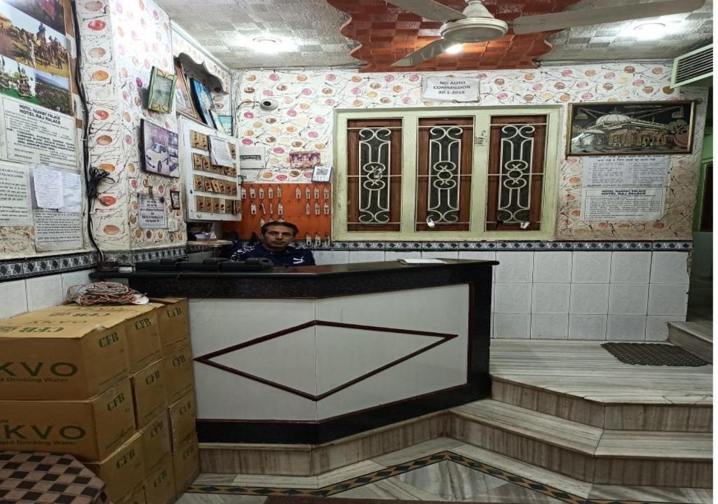 mężczyzna siedzący przy ladzie w kuchni w obiekcie Hotel Raahat Palace w mieście Adźmer