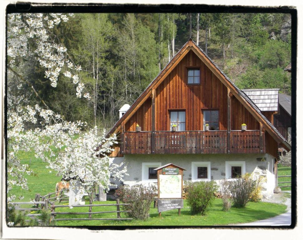 una grande casa in legno con un balcone sopra di Ferienhaus "Zur alten Schmiede" a Mariahof