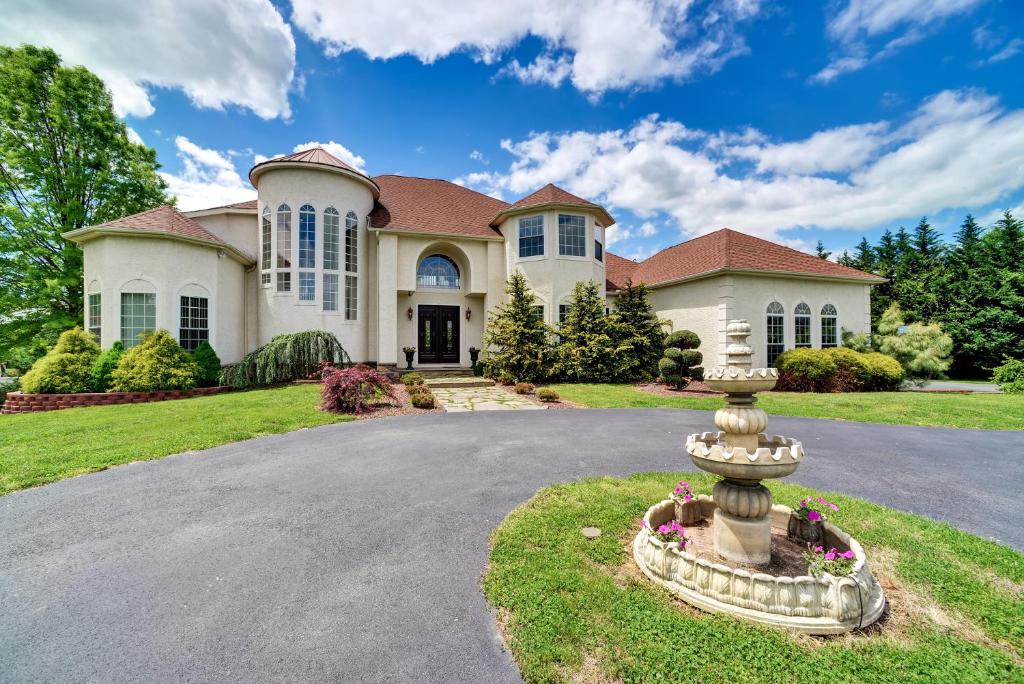 a house with a fountain in front of a driveway at Whispering Oak Mansion in Bear