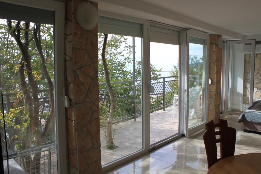 Zimmer mit Glasschiebetüren, die auf eine Terrasse führen in der Unterkunft Pile Apartments 7 in Omiš