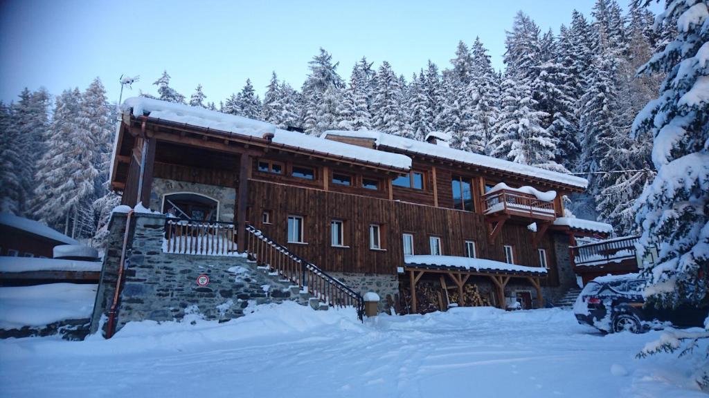 uma cabana de madeira na neve com árvores cobertas de neve em Chalet Iseran em Bourg-Saint-Maurice