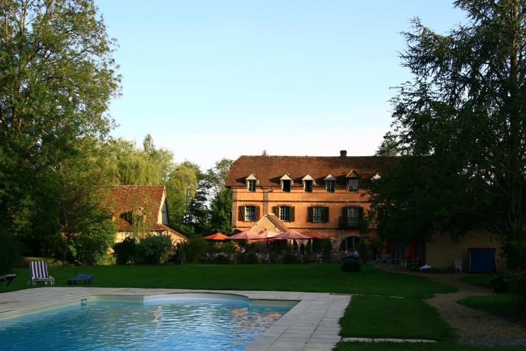 a large house with a swimming pool in front of it at Domaine De Villeray in Condeau