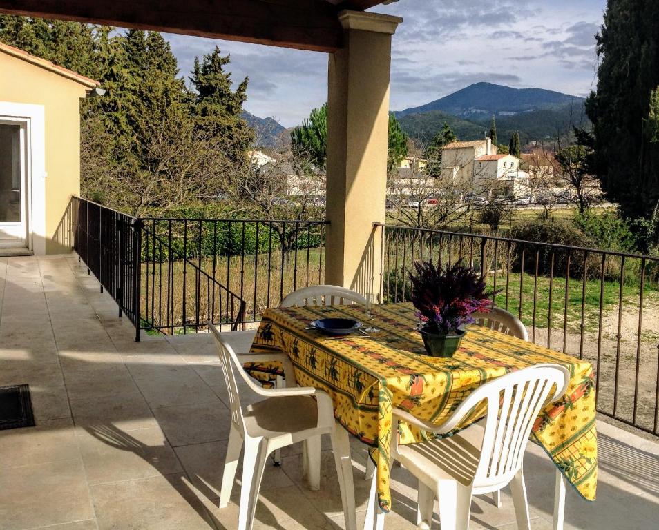 een tafel en stoelen op een patio met uitzicht bij Villa La Patachou in Malaucène