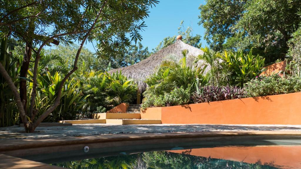 um resort com piscina e telhado de palha em Cabañas Amaia em Mazunte