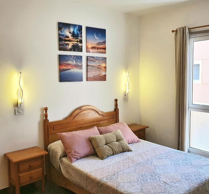 Un dormitorio con una cama con dos almohadas encima. en Vivienda FRALEMAR Arinaga., en Arinaga