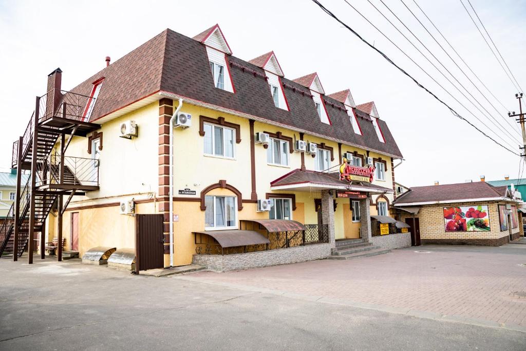 a large yellow building with a black roof at Diveevskiy Guest House in Diveevo