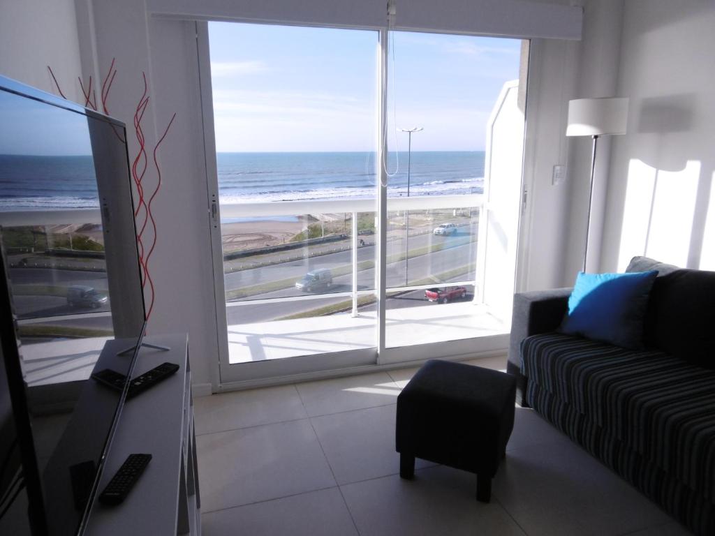ein Wohnzimmer mit einem Sofa und Meerblick in der Unterkunft DEPTOS VIP en EDIFICIO FRENTE AL MAR-ZONA CONSTITUCION in Mar del Plata